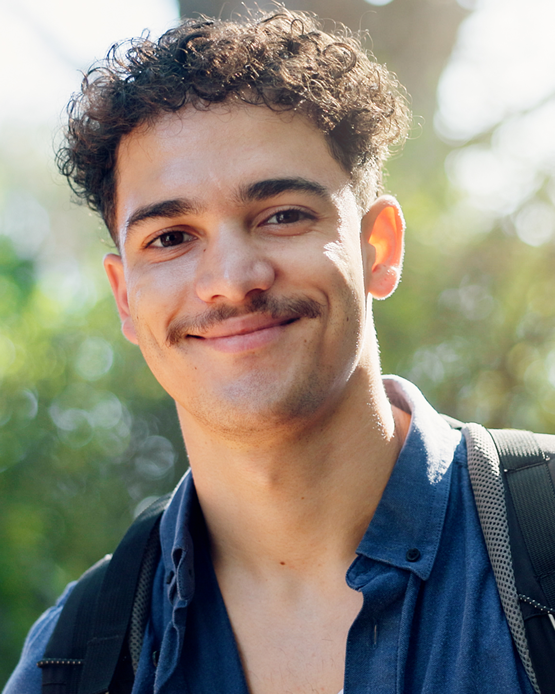 A photo of a smiling young mixed-race man